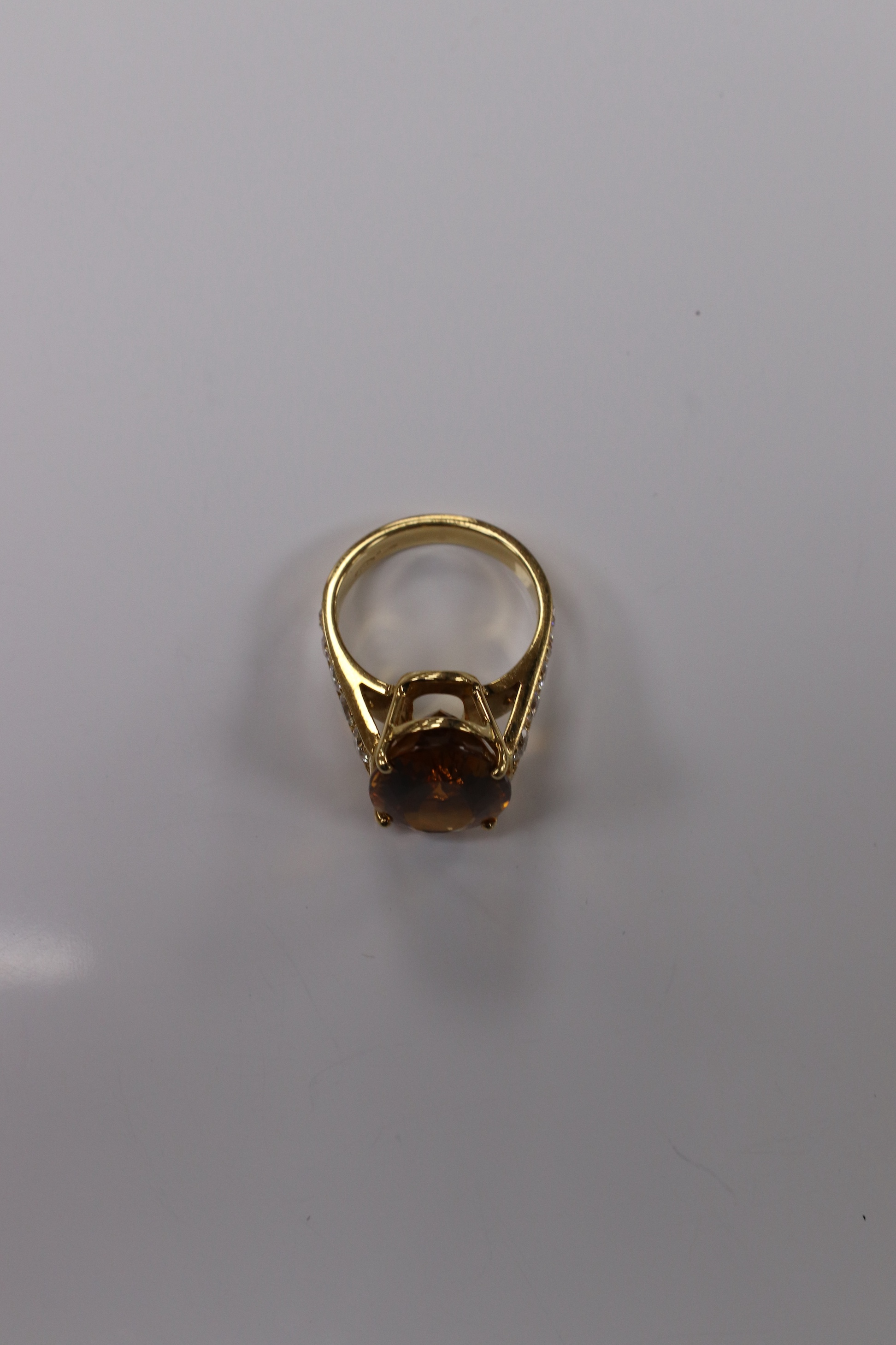 A modern 18k and single stone oval cut citrine set dress ring, with ten stone graduated diamond set shoulders, size K, gross weight 7,7 grams. Condition - good